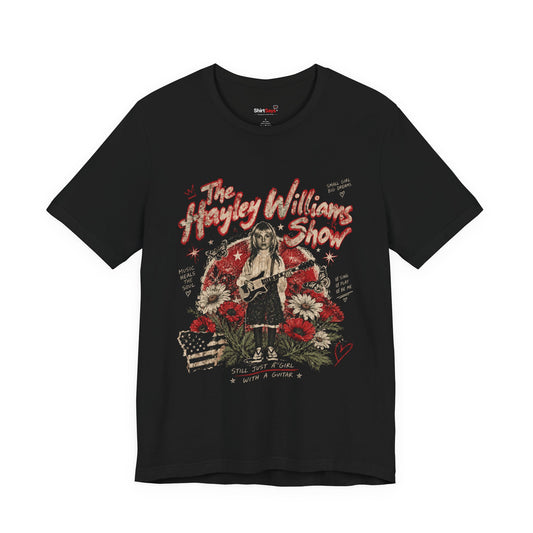 A black short-sleeve graphic t-shirt featuring a stylized illustration of Hayley Williams with the text 'The Hayley Williams Show' in red, set against a clean white background.